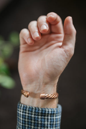 Kopero Pulseira de cobre Trançado, no pulso, com as pontas do fio torcido visíveis