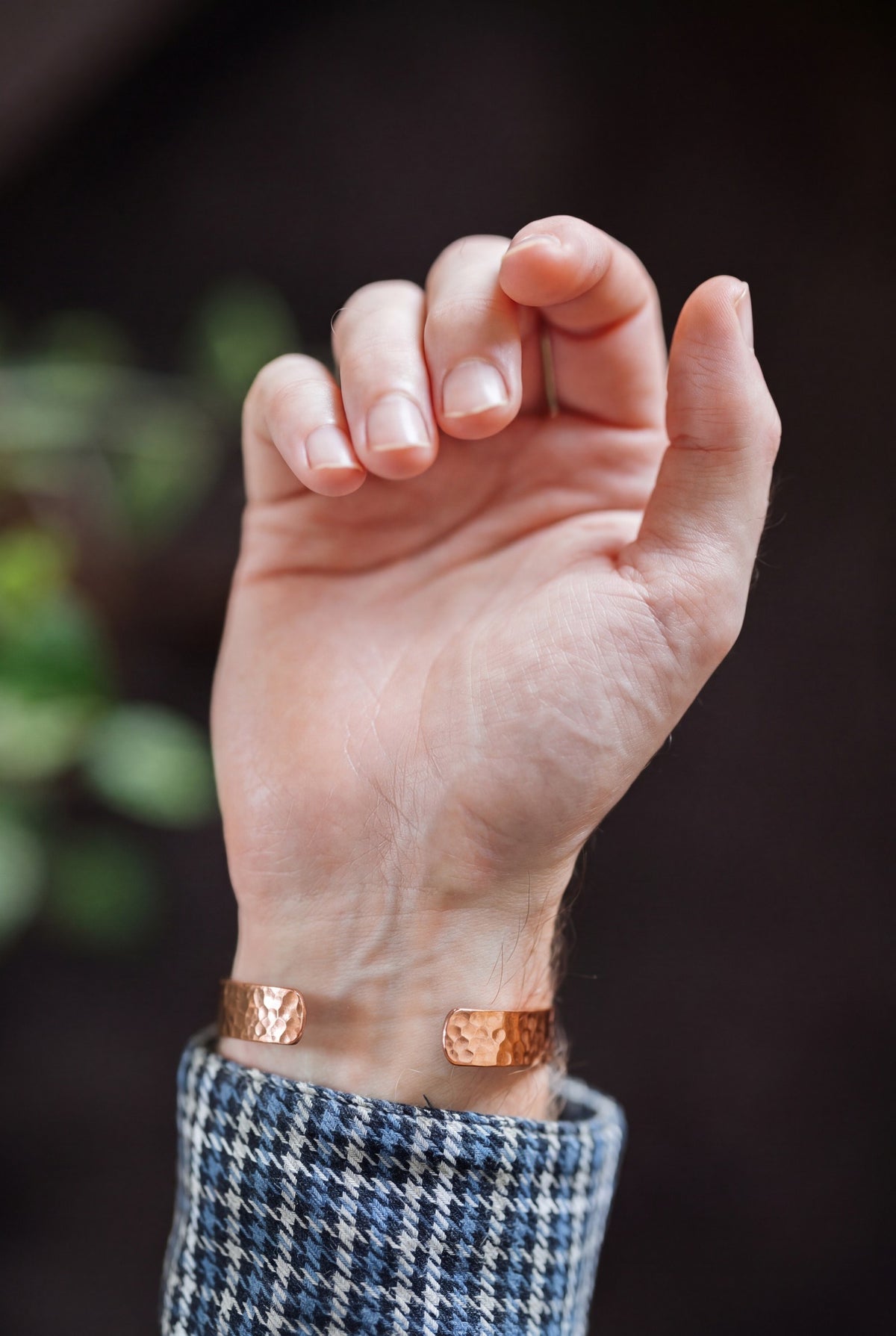 Kopero Pulseira de cobre Martelado, no pulso, com a mão aberta e as pontas da pulseira visíveis