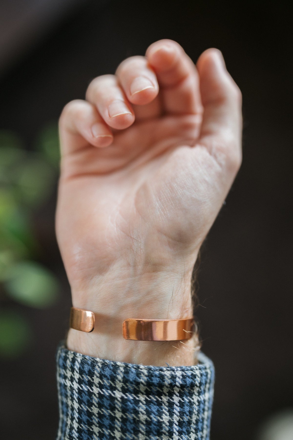 Kopero Pulseira de cobre Liso, no pulso, com a mão aberta e as pontas da pulseira visíveis