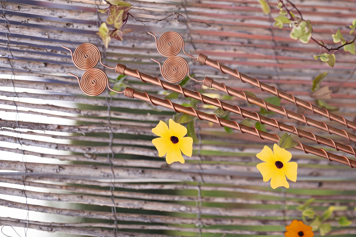 Antenas Kopero Eletrocultura de 60 cm junto a uma vedação de vime com trepadeira em flor