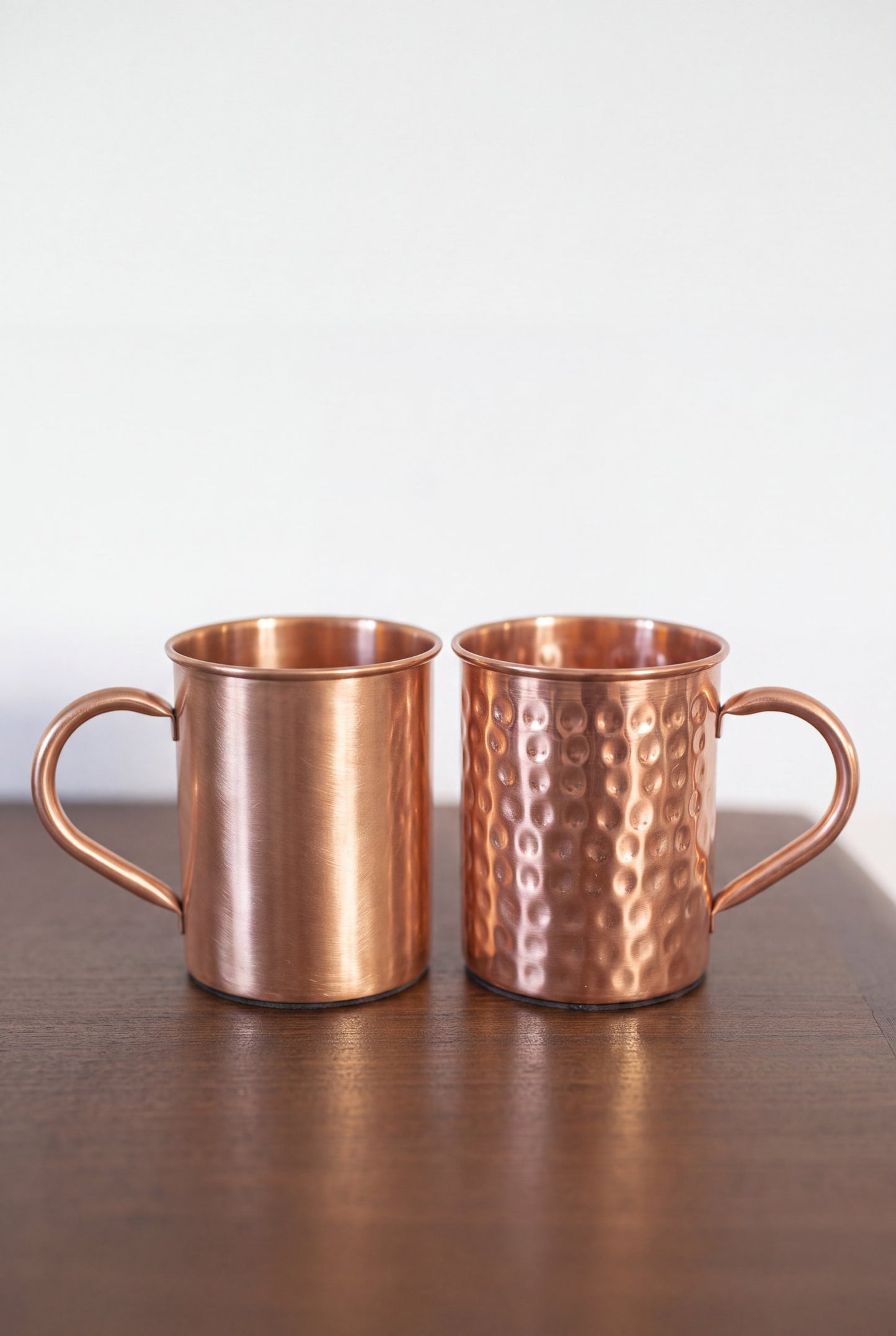 Kopero Caneca de Cobre, os dois acabamentos lado a lado sobre uma mesa de madeira