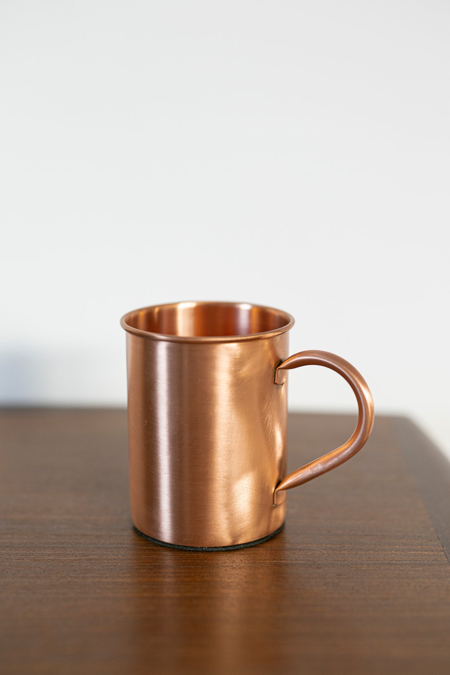 Caneca de cobre Kopero Premium Lisa, 400 ml, 100% cobre puro, close-up sobre mesa de madeira
