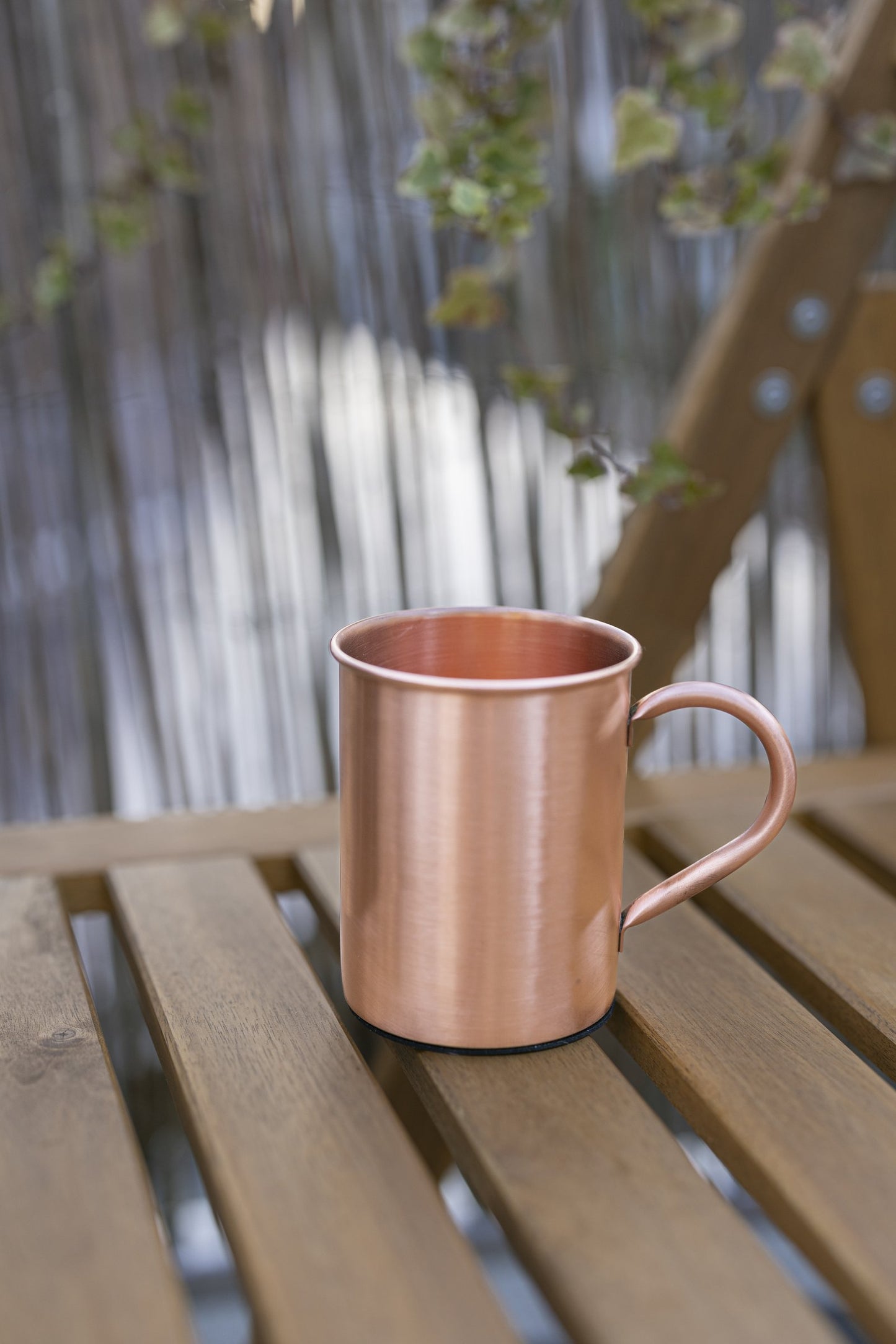 Kopero Caneca de Cobre Lisa de 400 ml sobre um banco de jardim de madeira