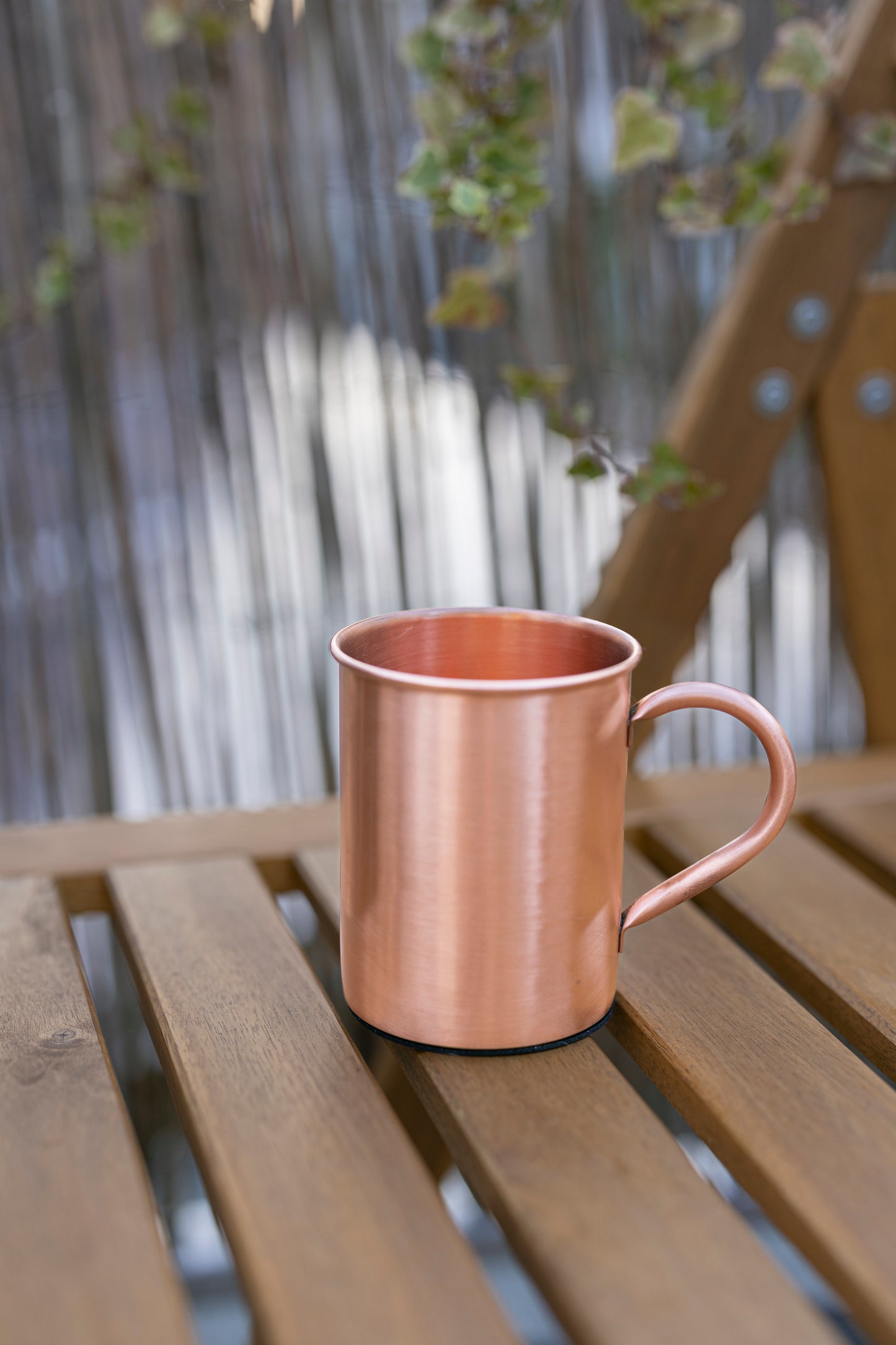 Caneca de cobre Kopero Premium Lisa, 400 ml, 100% cobre puro, ao ar livre numa mesa de jardim em madeira