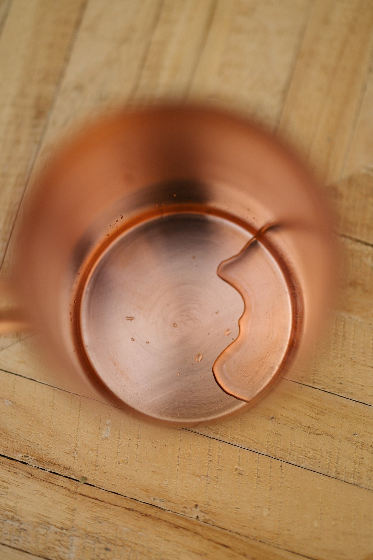 Kopero Caneca de cobre Liso, visto de cima: o interior da caneca sobre uma mesa de madeira