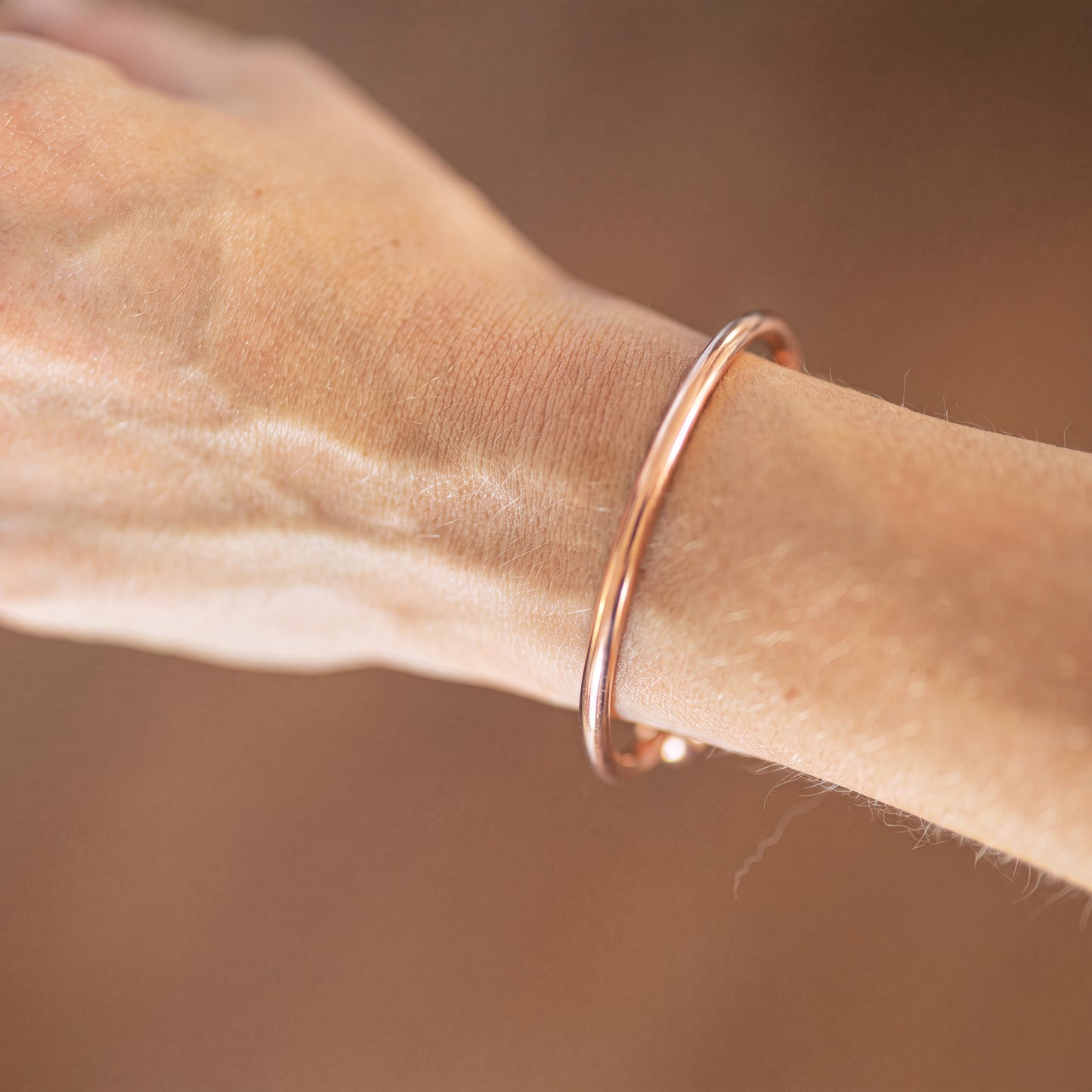 Kopero Premium Pulseira de Cobre Redonda, fotografia de pormenor da pulseira redonda e lisa sobre a pele