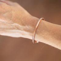 Kopero Premium Pulseira de Cobre Redonda, fotografia de pormenor da pulseira redonda e lisa sobre a pele